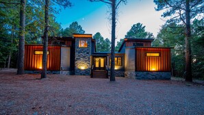 Eine moderne Holzhütte mit Steinfassade, Holzverkleidung und einem zentralen Eingang mit Stufen.