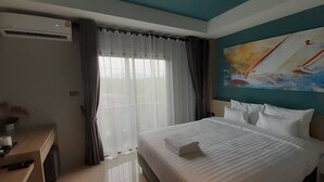 Una habitación de hotel con una cama, un escritorio y un cuadro en la pared.