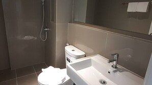 Un baño moderno con inodoro, lavabo y ducha.