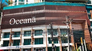 Un hotel con un llamativo letrero 'Oceana', varios pisos y un diseño arquitectónico moderno.