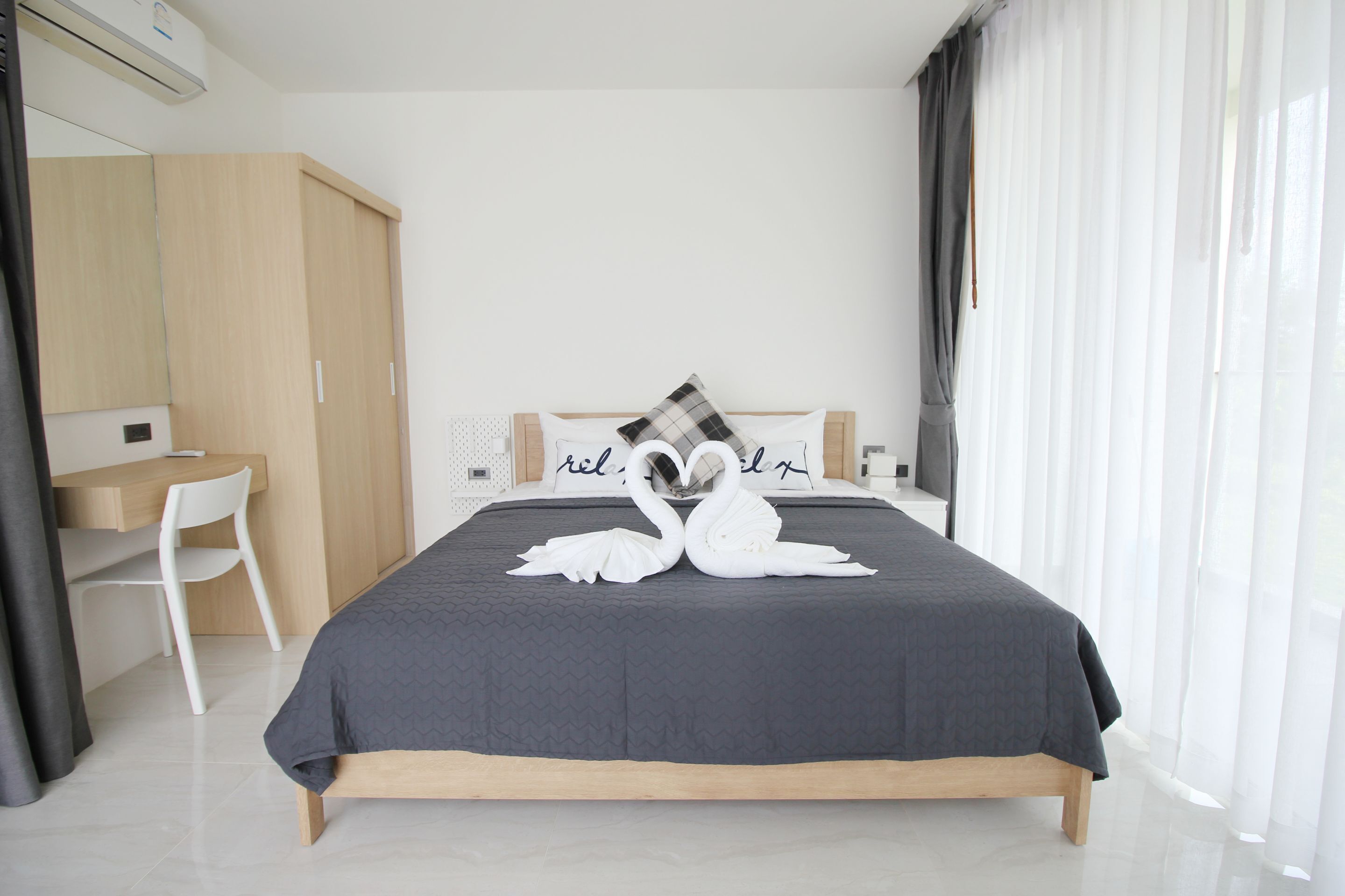 A modern bedroom with a bed, a desk, and a chair.