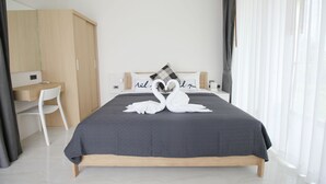 Un dormitorio moderno con cama, escritorio y silla.