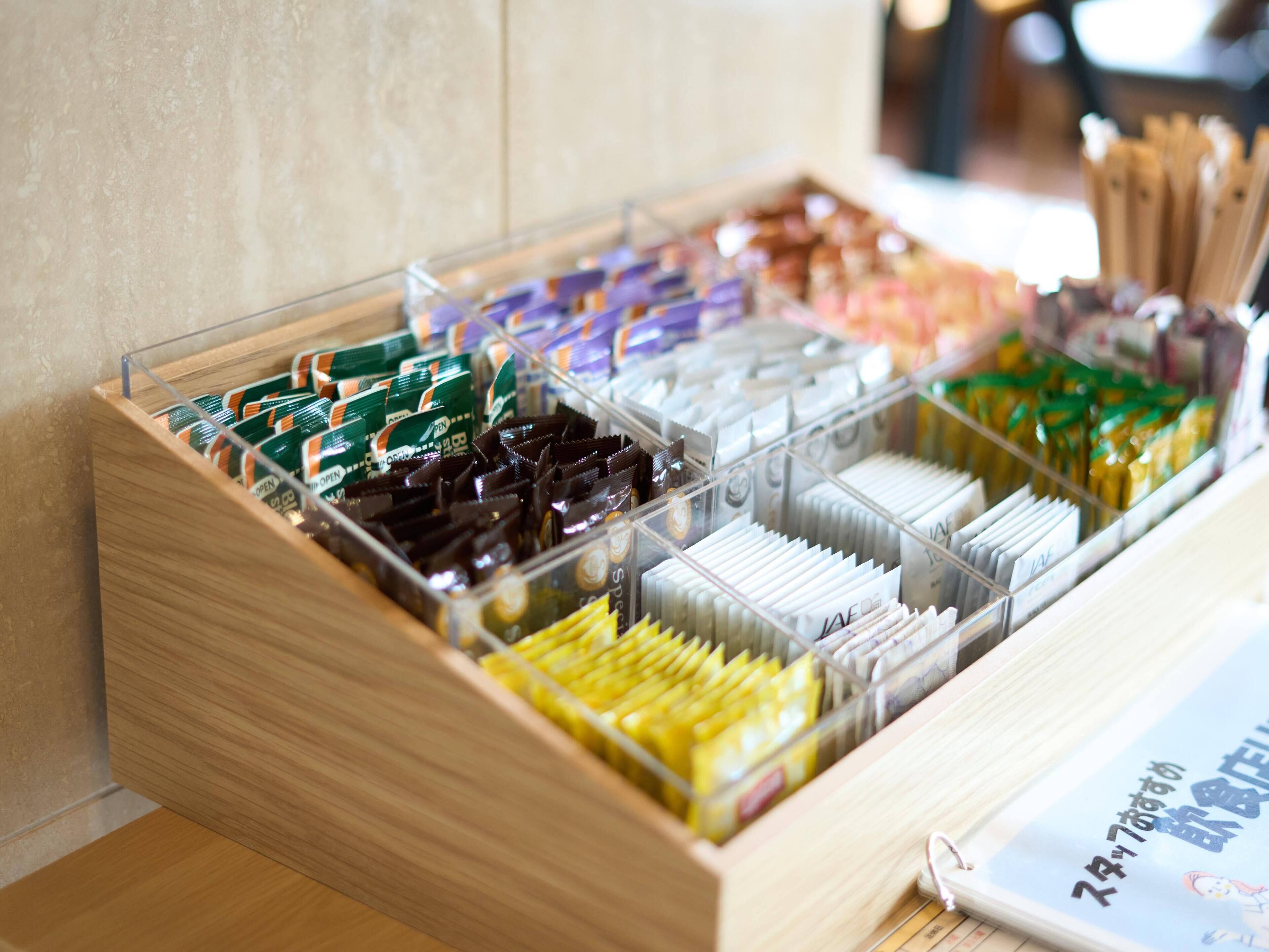 Een transparante opbergbox met vakken waarin verschillende verpakte items zitten.