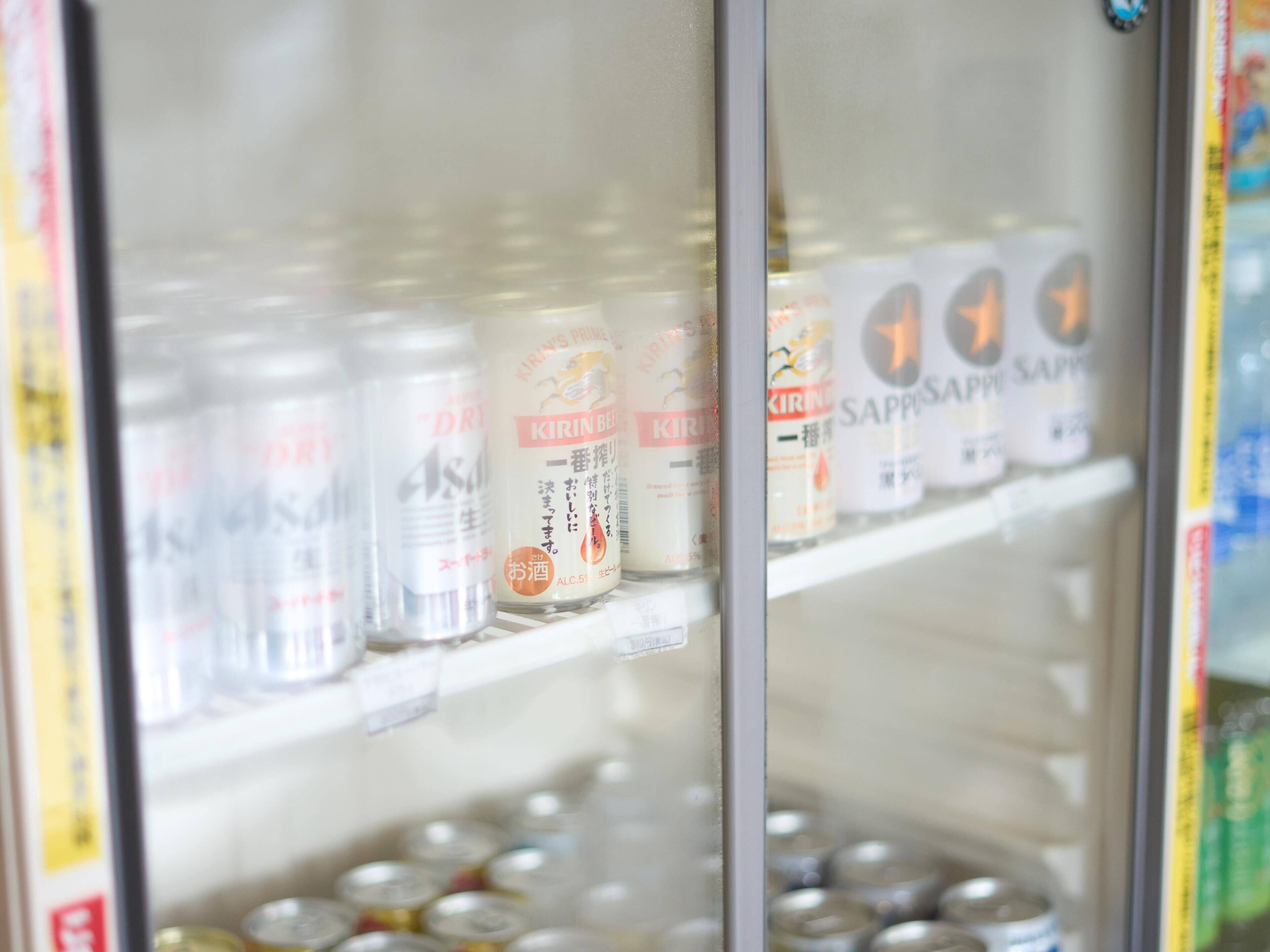 Un refrigerador para bebidas repleto de diversas opciones, incluyendo cerveza Kirin y Sapporo.