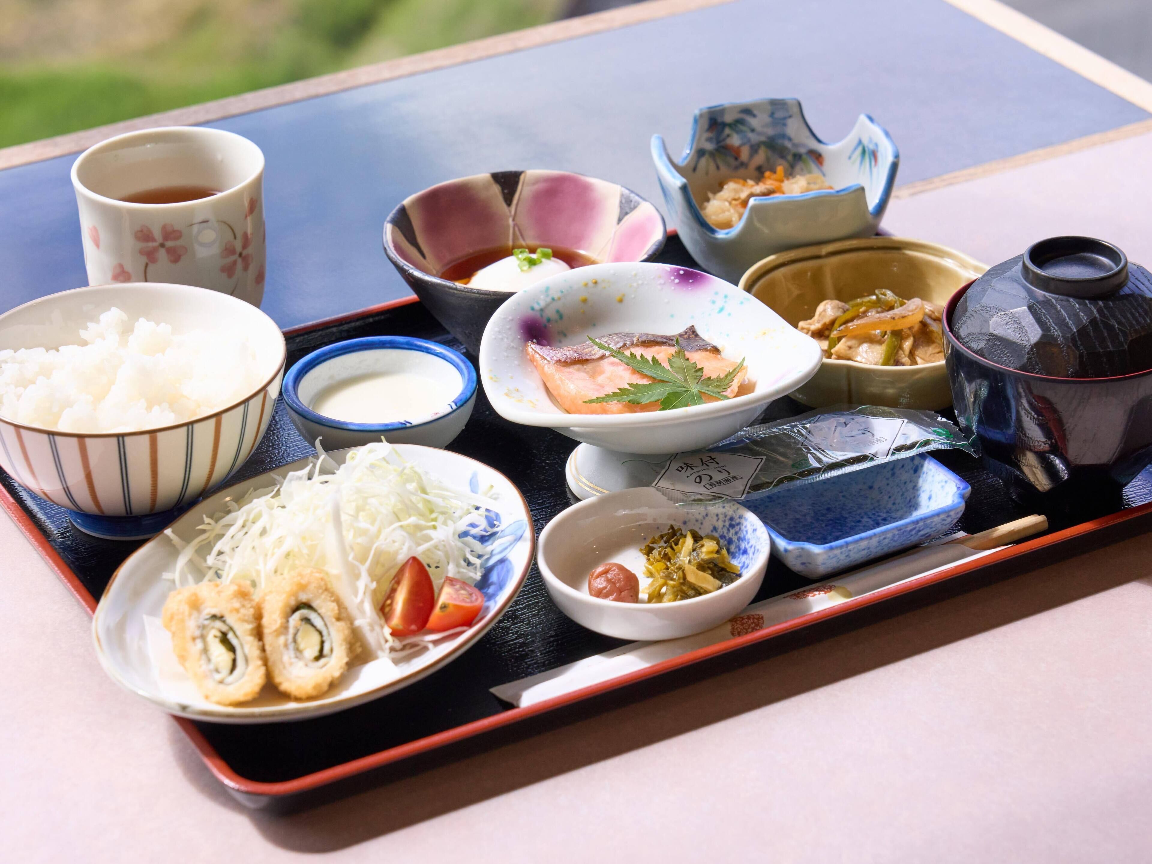 A tray with various Japanese dishes including sushi, rice, and soup.