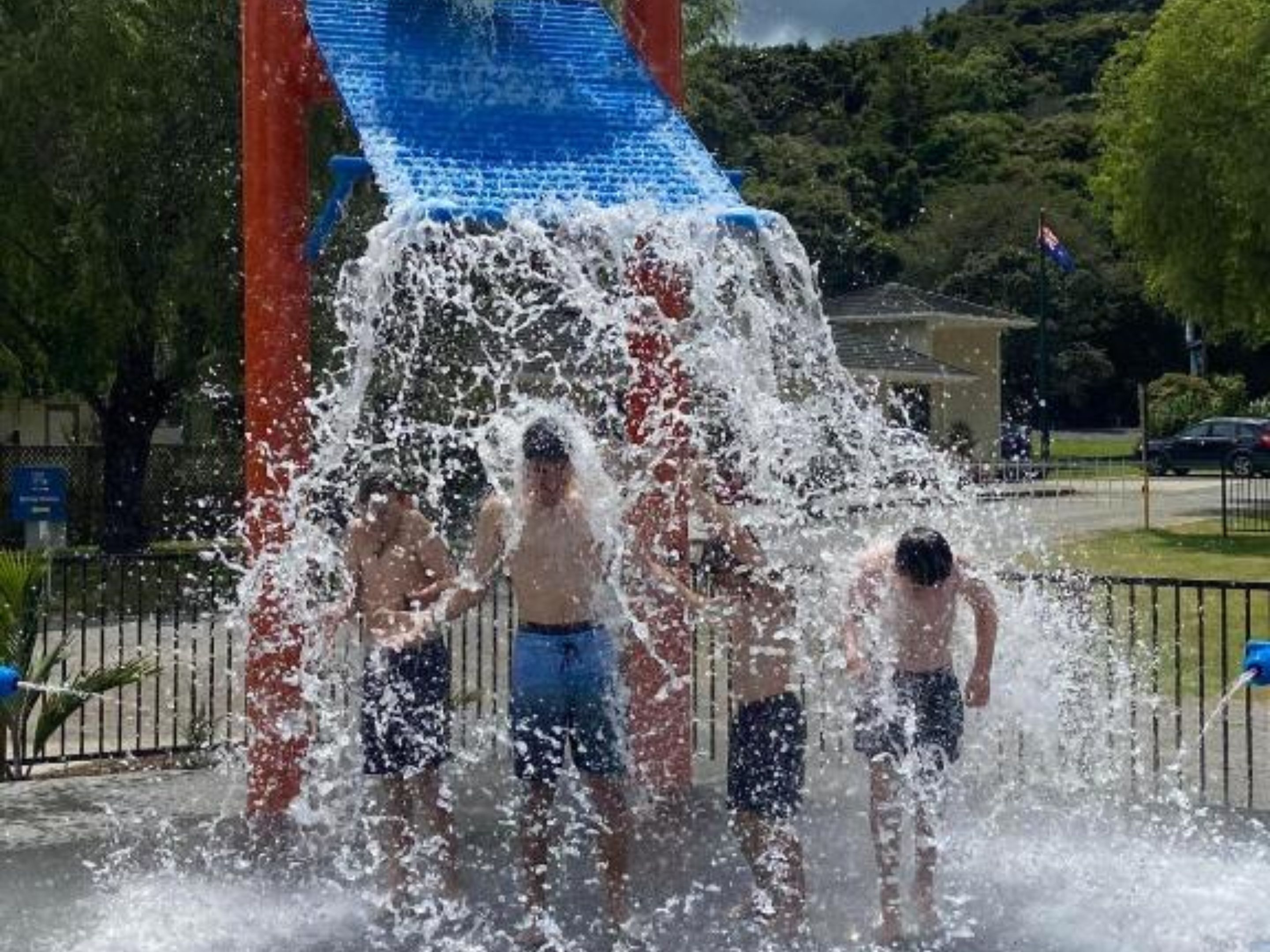 A water slide with three people at the bottom.