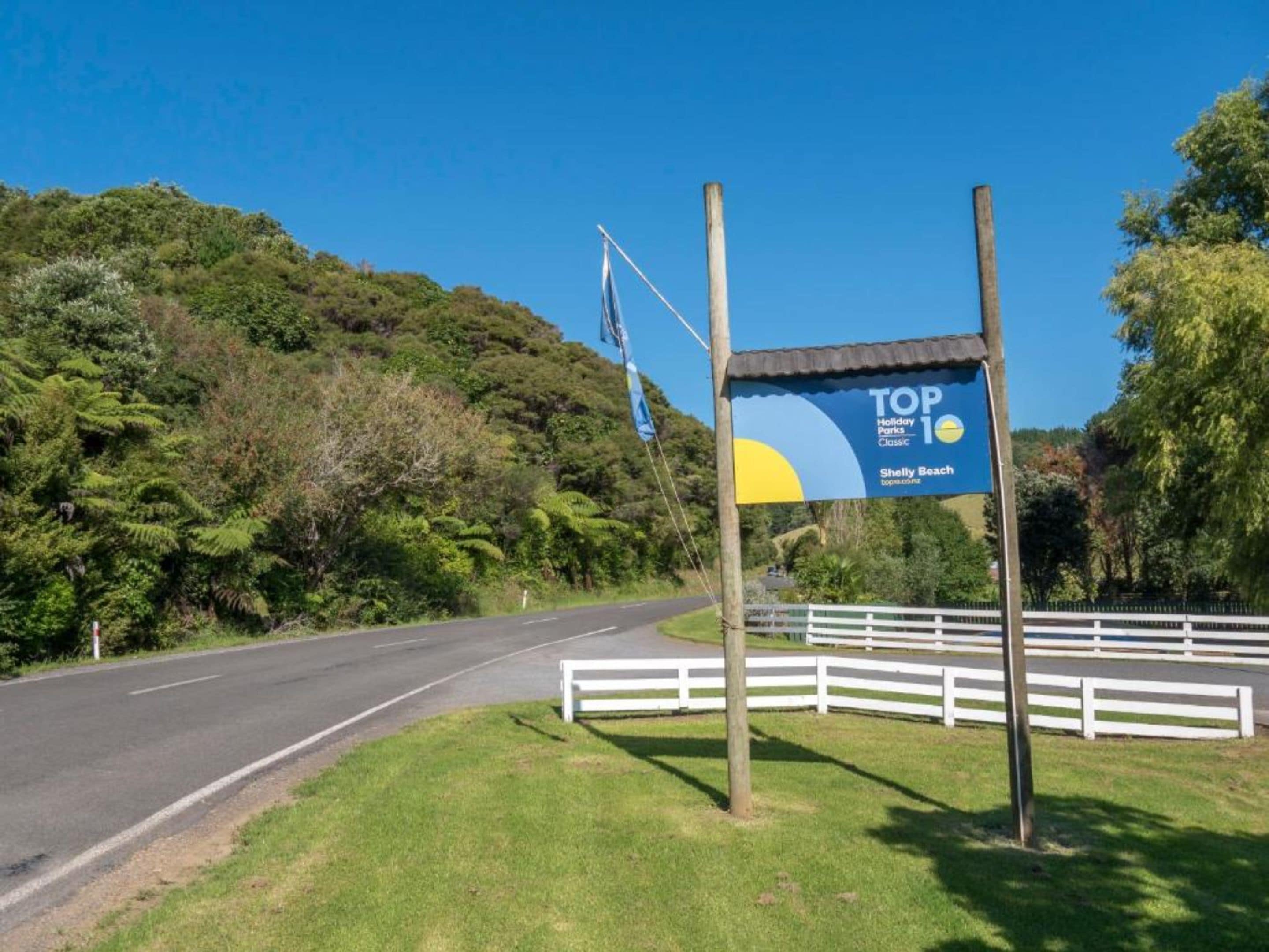 A road sign indicating Shelly Beach as a top holiday park.