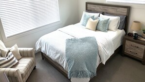 A bedroom with a bed, bedside table, lamp, and chair. - ★Home away from Home ★ (Tremonton)