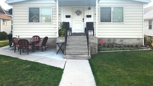 A single-story house with a front porch, a dining area with four chairs and a table, and a small garden. - ★Home away from Home ★ (Tremonton)