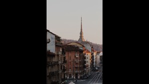 A street view with buildings, a prominent church spire, and a clear sky.