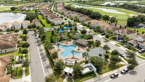 Ein Wohngebiet mit Häusern, einem Schwimmbad und einem Golfplatz im Hintergrund.