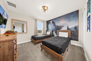 Une chambre avec deux lits, une commode, un miroir, une fenêtre et une grande fresque murale.