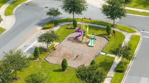 An aerial view of a playground with a slide, swings, and a climbing structure.