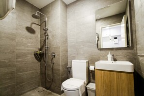 A modern bathroom with a shower, toilet, sink, and mirror. - Aurora Pavilion Bukit Jalil by Ody Suites (Kuala Lumpur)