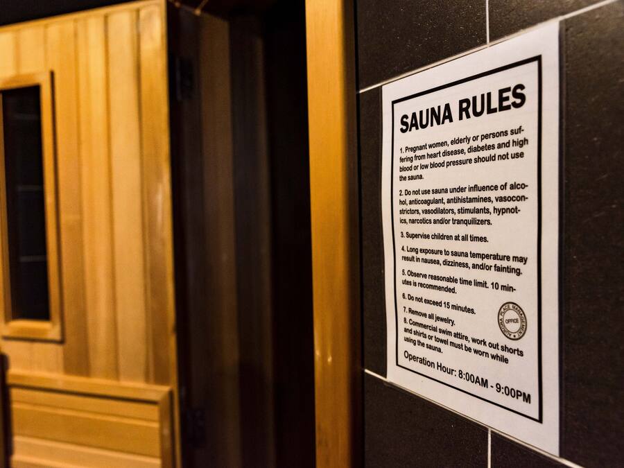 A sign listing sauna rules, including a 10-minute time limit and a 15-minute maximum duration.