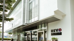 A modern building with glass doors, a sign reading "REV.", and a parking sign. - Aurora Pavilion Bukit Jalil by Ody Suites (Kuala Lumpur)