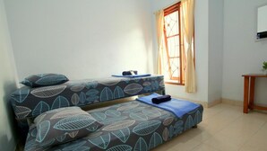 A room with a bed, a small table, and a window with curtains.