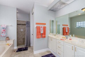 A bathroom with a shower, a sink, and a large mirror. - Bailey Rose - Luxury Home Sailboat Access Canal (Cape Coral)