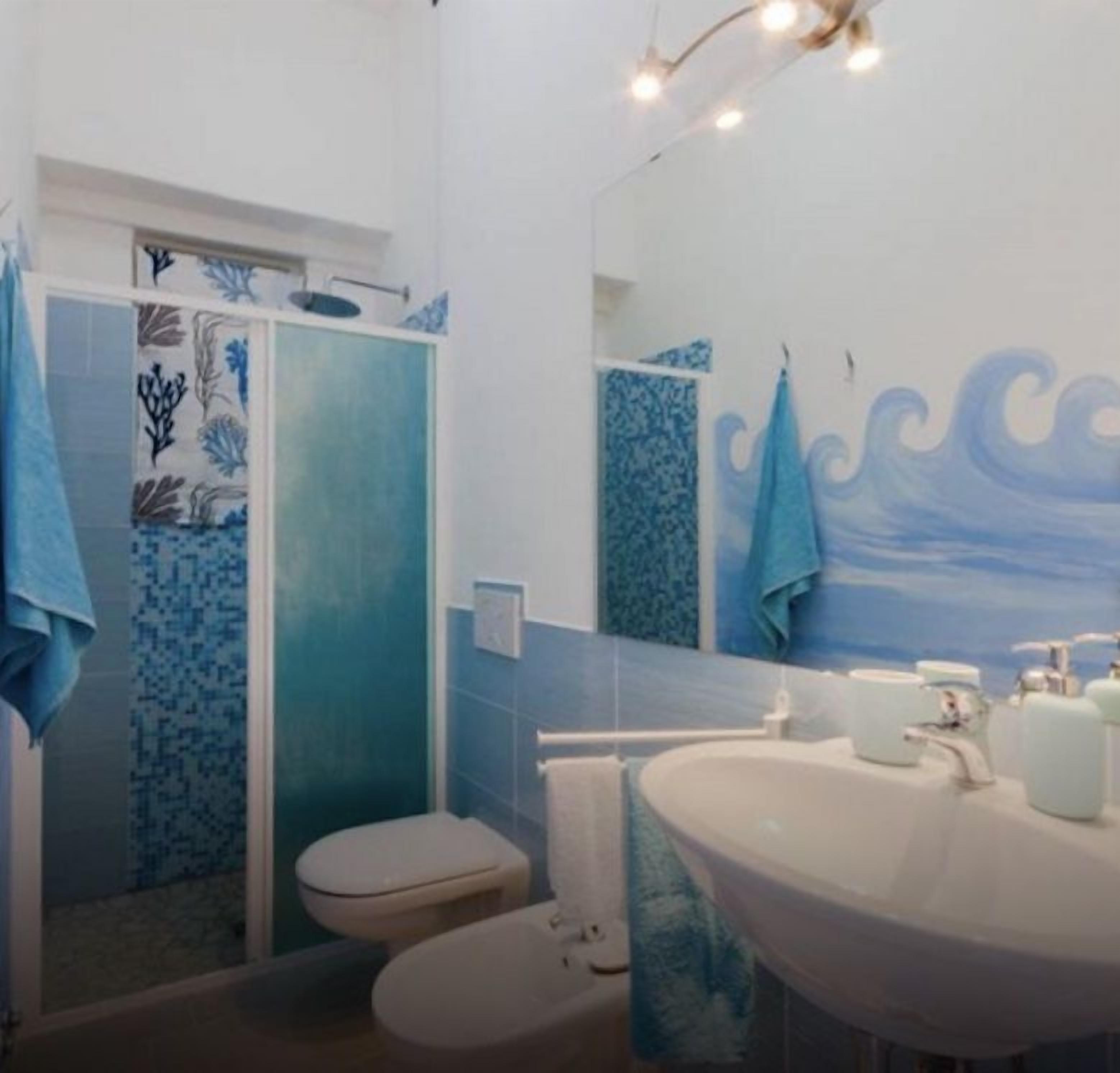 A bathroom with a shower, toilet, and sink.