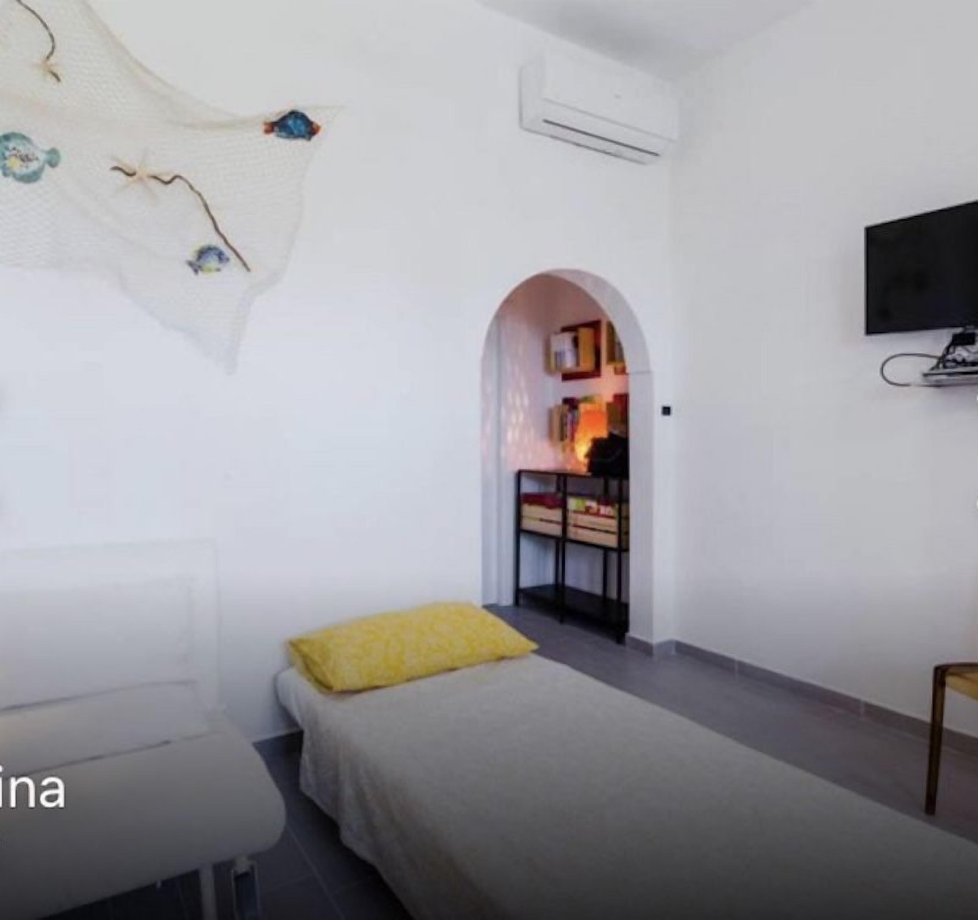 Une chambre à coucher moderne avec un lit, un canapé, un fauteuil et un téléviseur.