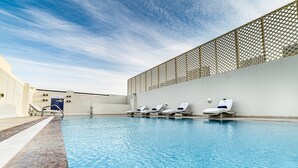 Une piscine équipée de chaises longues et d’une structure servant de parasol.