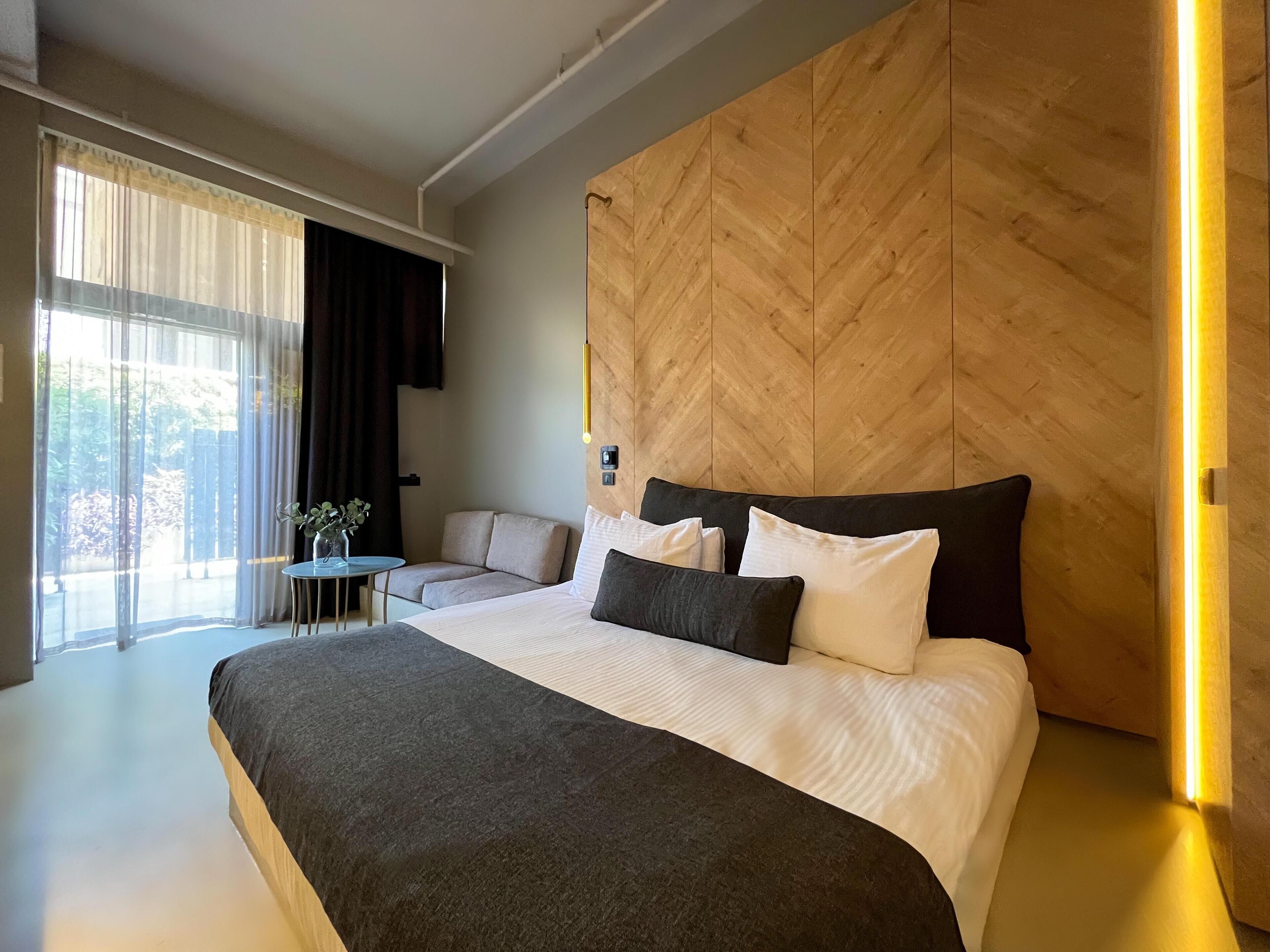 Un dormitorio moderno con una cama grande, un sofá y una mesita.