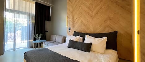 Un dormitorio moderno con una cama grande, un sofá y una mesita.