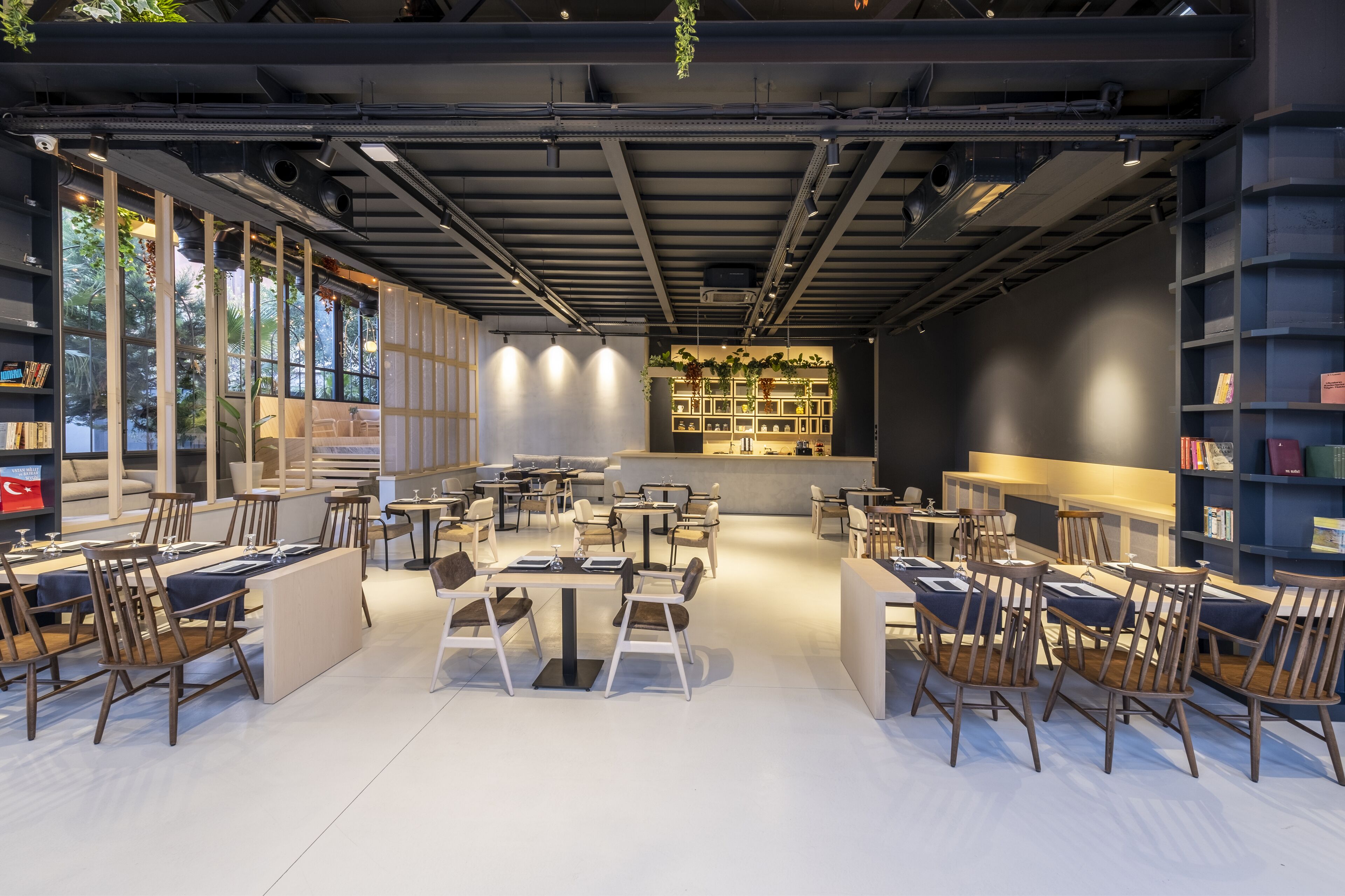 Un interior moderno con una zona de estar central, estanterías y una barra.
