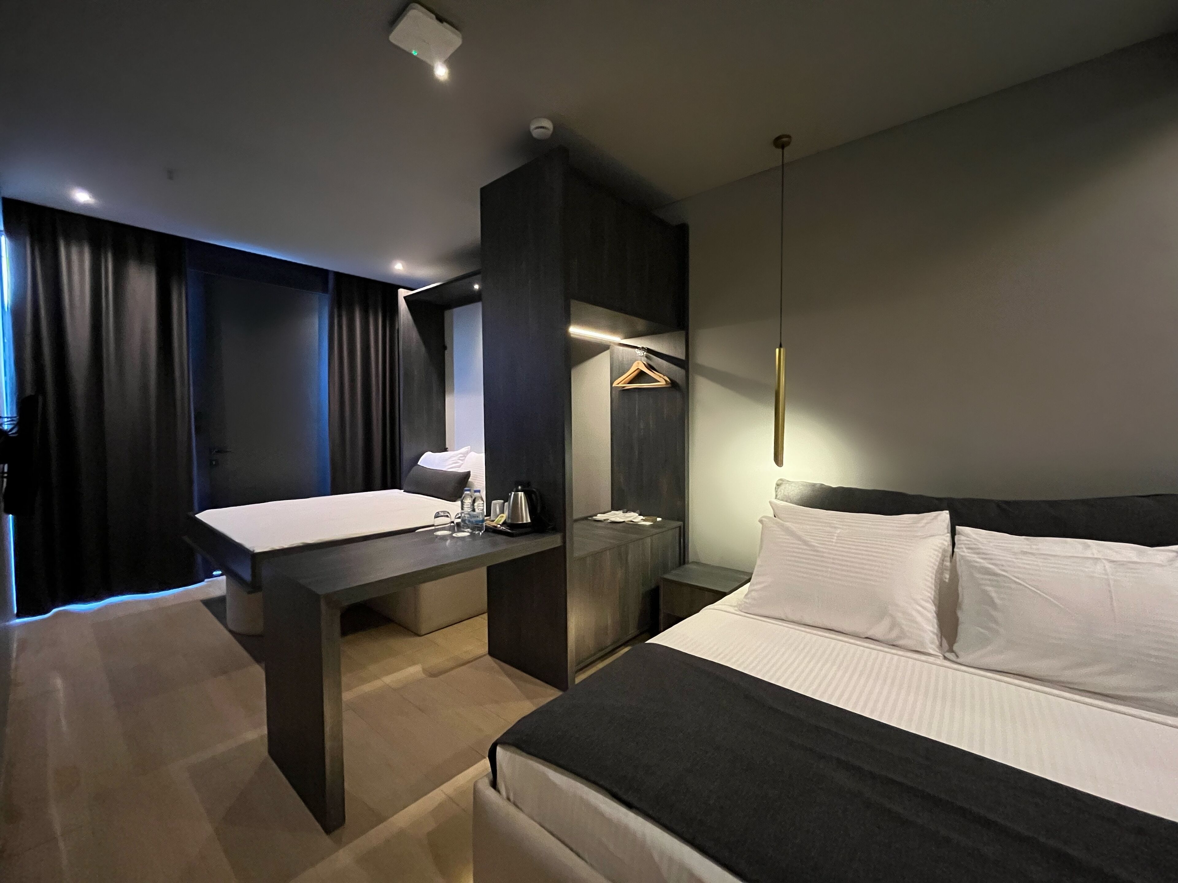 Une chambre d’hôtel moderne équipée d’un lit, d’une table de chevet et d’un bureau avec une chaise.