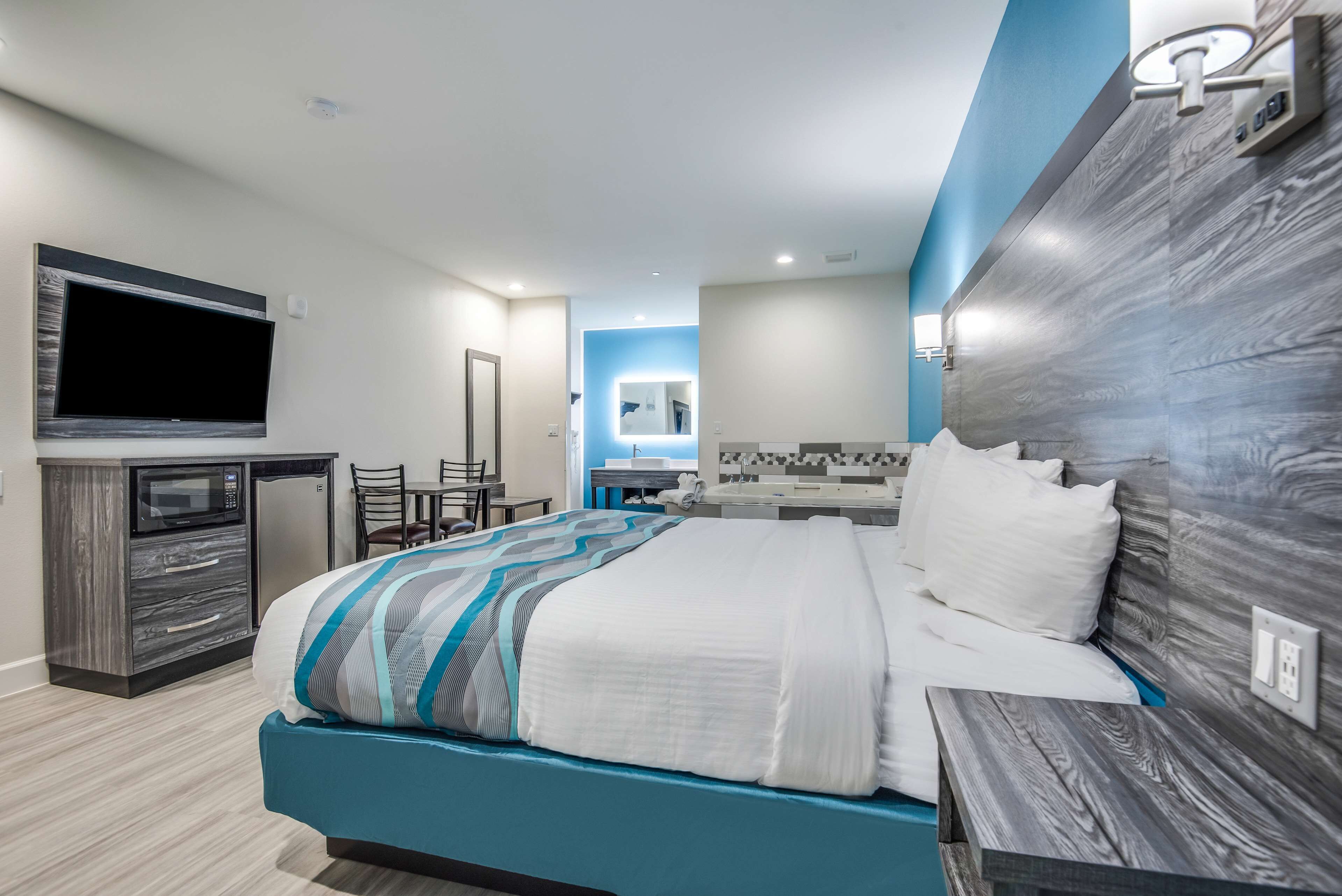 suite, 1 king bed, smoking, jetted tub | desk, laptop workspace, iron/ironing board, bed sheets