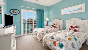 A bedroom with two beds, a TV, and a balcony with a view. - Stunning marsh view home, gorgeously furnished, private pool - walk to beach - perfect area (North Myrtle Beach)