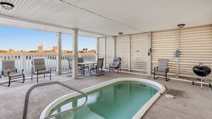 An outdoor pool area with a pool, lounge chairs, and a barbecue grill. - Stunning marsh view home, gorgeously furnished, private pool - walk to beach - perfect area (North Myrtle Beach)