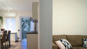 Un soggiorno moderno con un divano marrone e un'area da pranzo con tavolo e sedie.