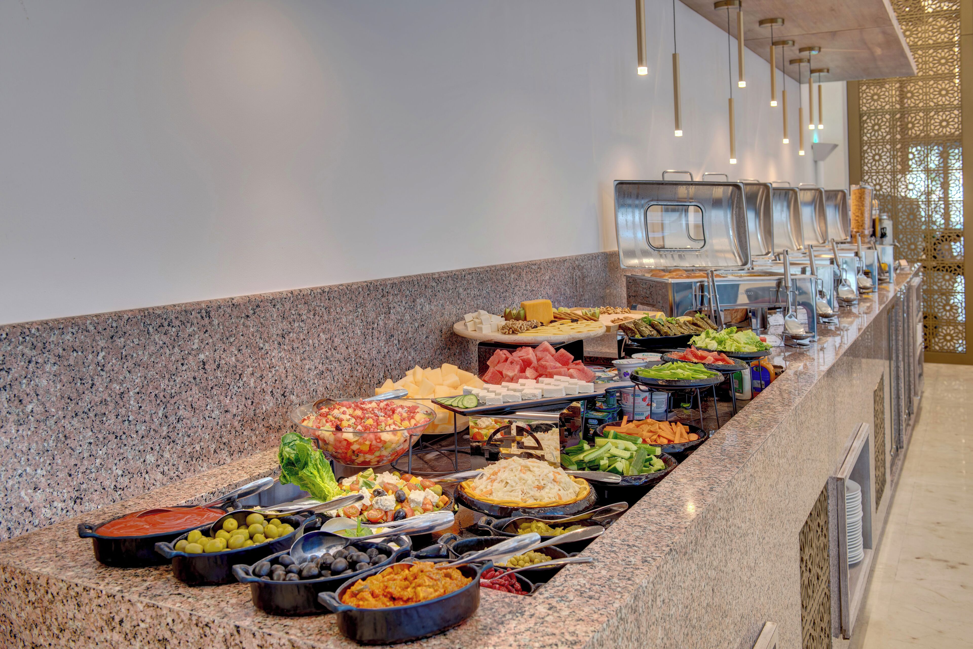 Un buffet proposant une variété de plats et d’ustensiles de service.