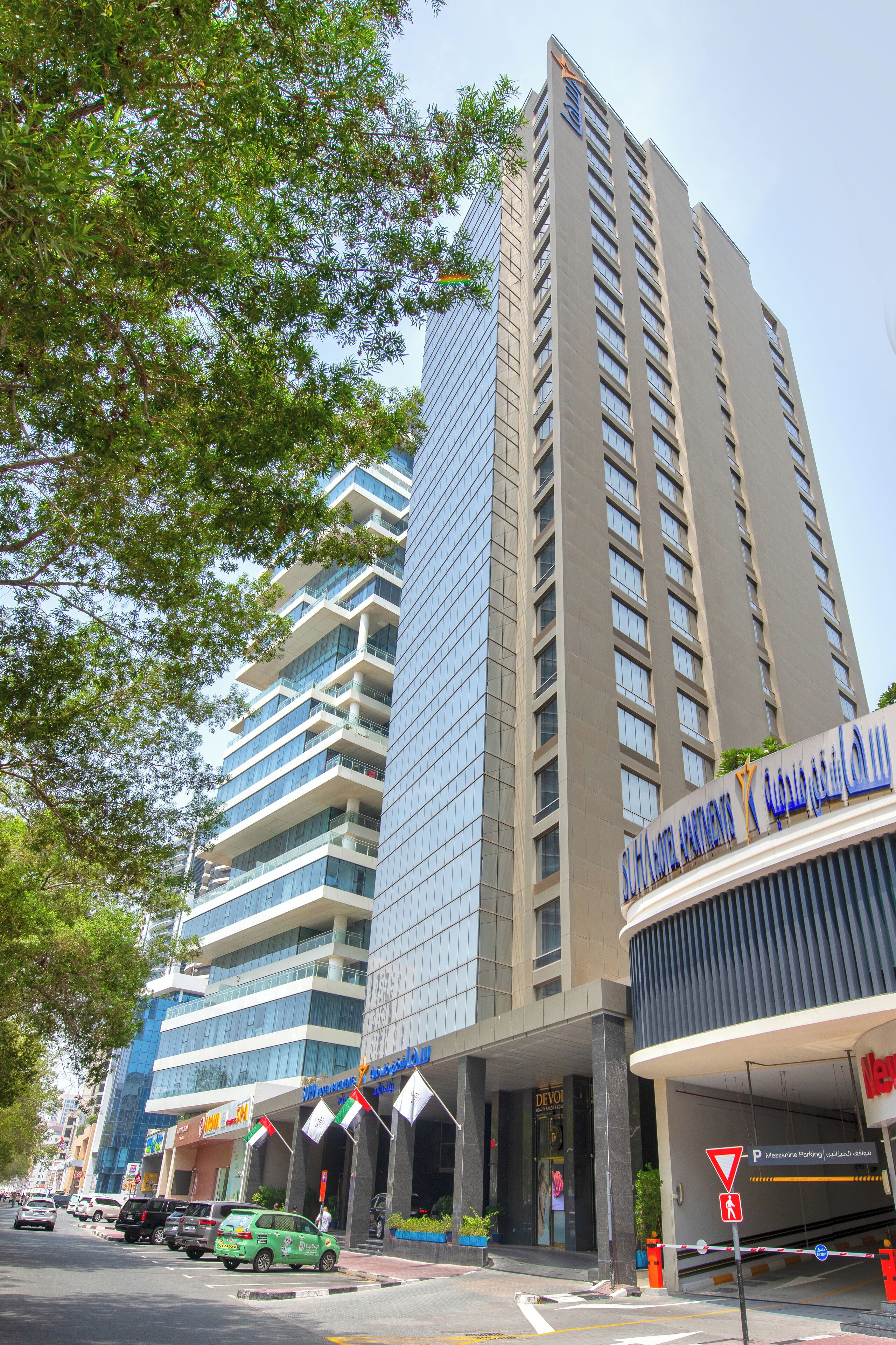 Un hôtel moderne, doté de nombreux étages, de grandes fenêtres et d’une entrée imposante.