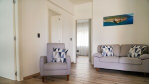 A living room with a grey armchair and a grey sofa, both with patterned cushions. - House stefi 2 M0230450730 (Malcesine)