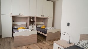 A bedroom with two beds, a wardrobe, and a desk. - House stefi 2 M0230450730 (Malcesine)