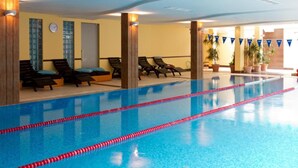 An indoor swimming pool with clear lane dividers, sun loungers, and potted plants. - Aparthouse Borovo (Sofia)