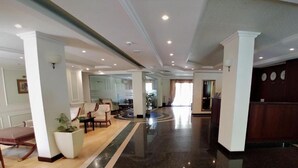 A spacious lobby with a polished marble floor, a reception desk, and a seating area with chairs and a table. - Aparthouse Borovo (Sofia)
