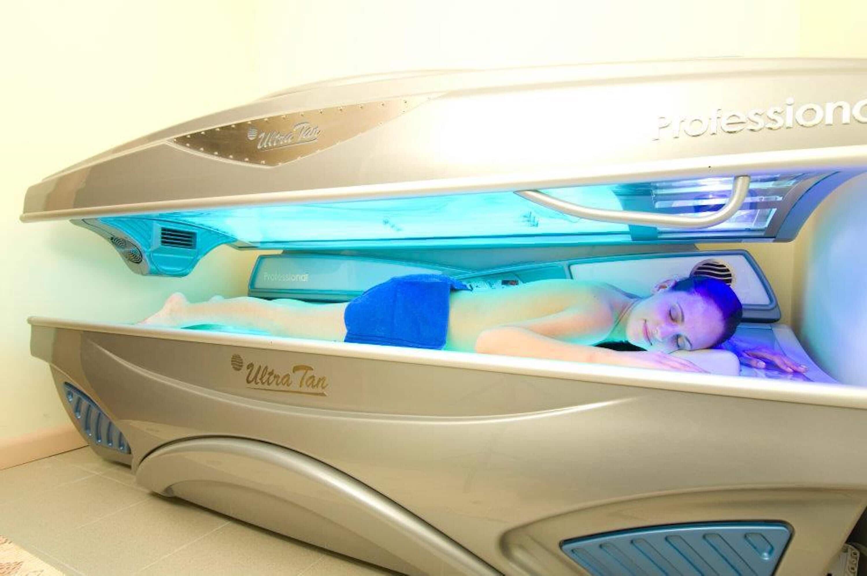 Una cama bronceadora con una persona acostada en su interior, etiquetada como "Ultravioleta".