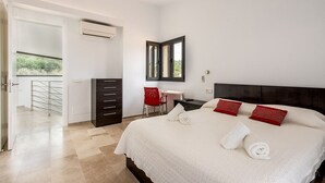 Une chambre d’hôtel comprenant un lit, un bureau, une chaise, une armoire et un balcon.