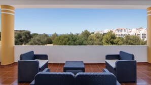 A balcony with wicker furniture and a view of buildings and trees. - Holiday Home "Villa Do Lago" with Sea View, Balcony, Garden & Pool (Albufeira)