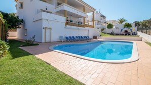 A two-story building with a swimming pool, a covered patio, and a small garden area. - Holiday Home "Villa Do Lago" with Sea View, Balcony, Garden & Pool (Albufeira)
