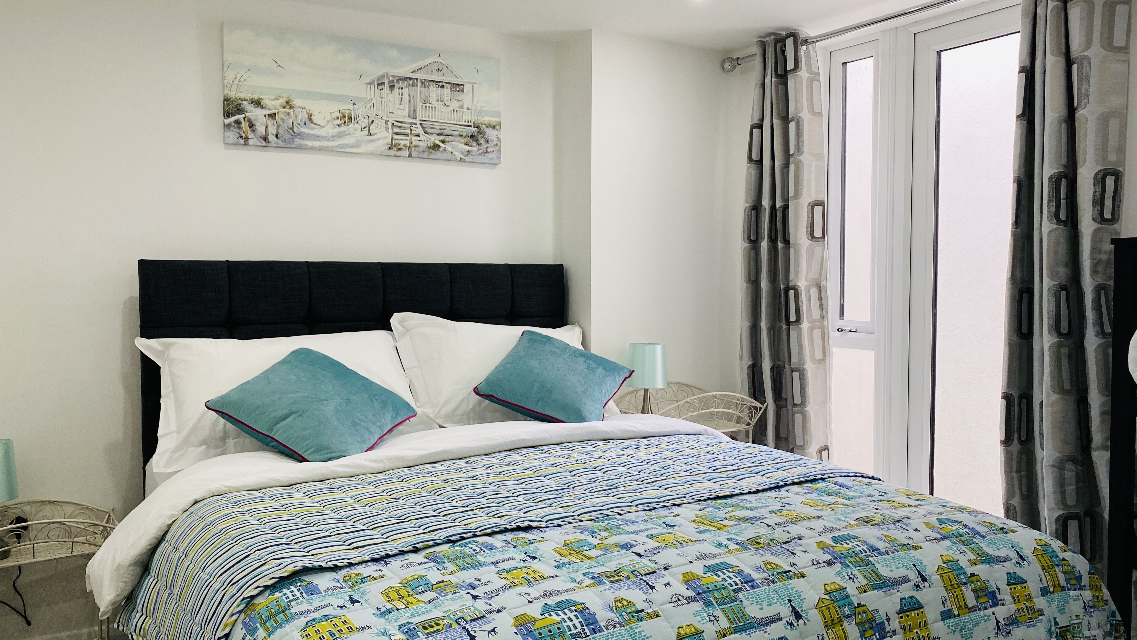 A neatly made bed with a patterned bedspread, two pillows, and a headboard.
