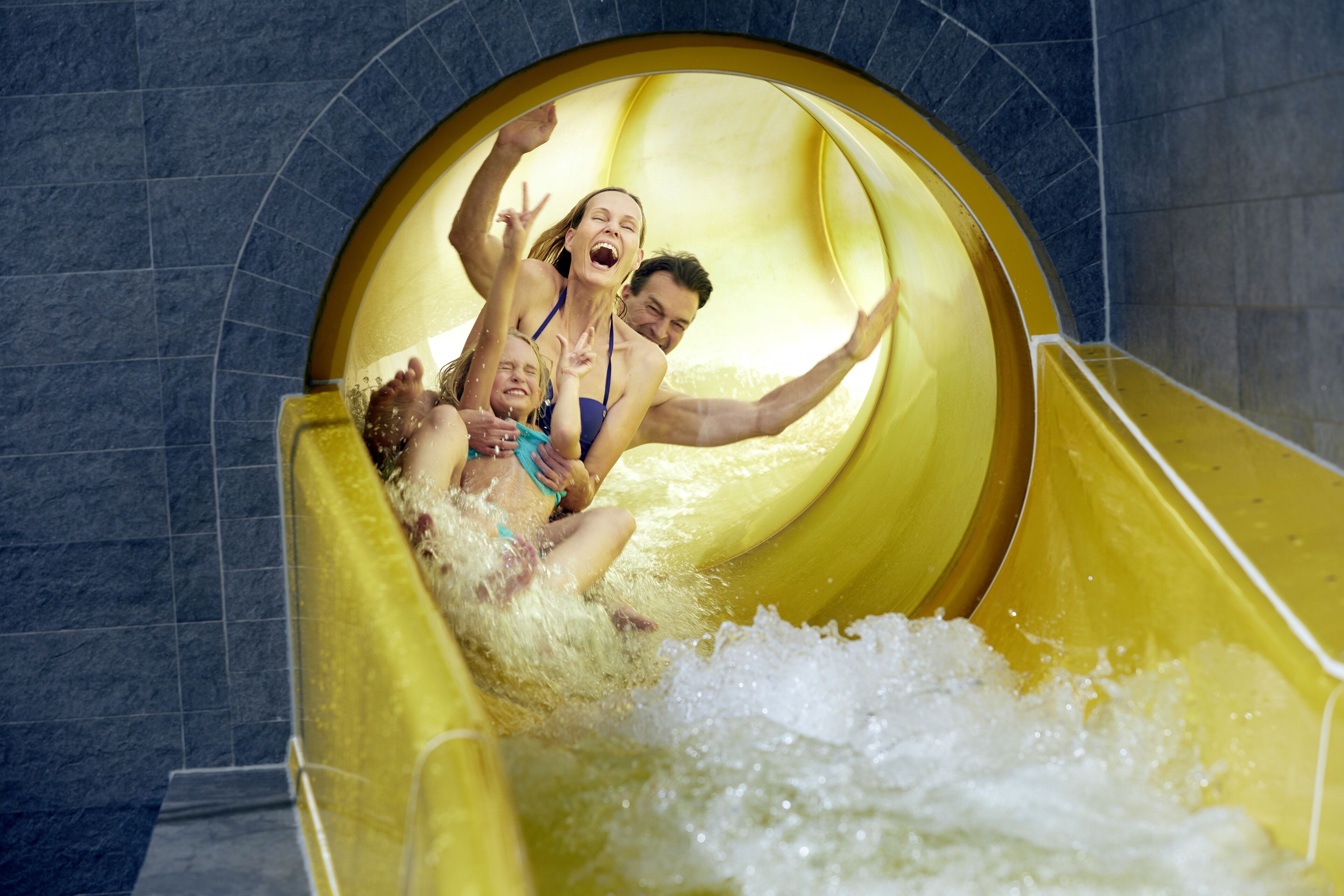 A water slide with people sliding down.