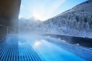 A spa area with a view of a snow-covered forest and mountains. - Almhof Family Resort & SPA (Gerlos)