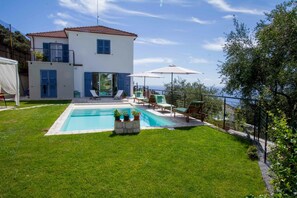 Alberca al aire libre y camastros