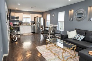 A modern living room with a glass coffee table, a black sofa, and a patterned rug. - FIFA World Cup: NoHo MODERN 2BR TOWNHOME w/ PRIVATE FENCED PATIO & PARKING p20 (Los Angeles)