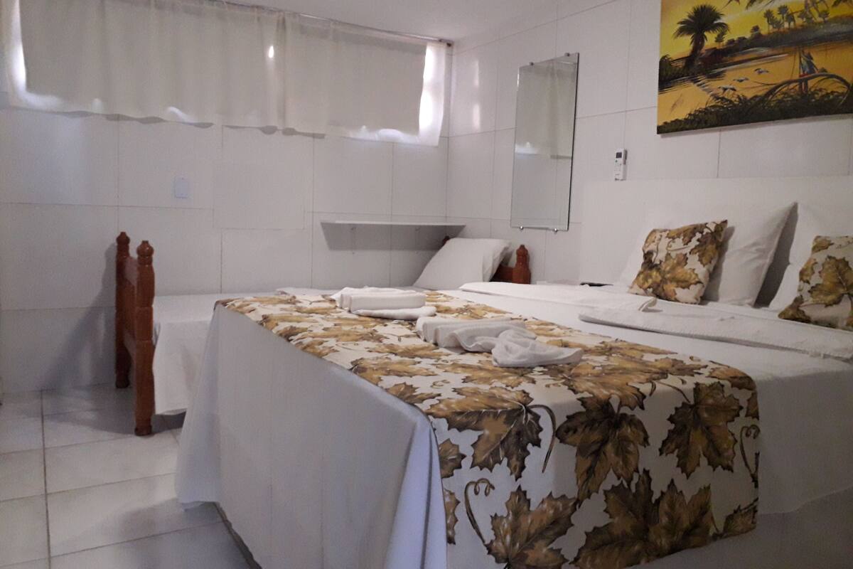 Habitación de hotel con dos camas, un espejo grande y un cuadro en la pared.