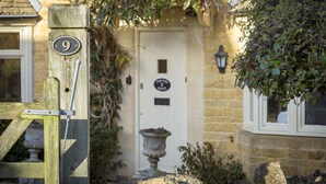 A stone building with a white door, a number 9 sign, and a stone lantern. - Chipping Campden Modern House, Garden, upstairs/downstairs bedrooms/bathrooms.  (Chipping Campden)